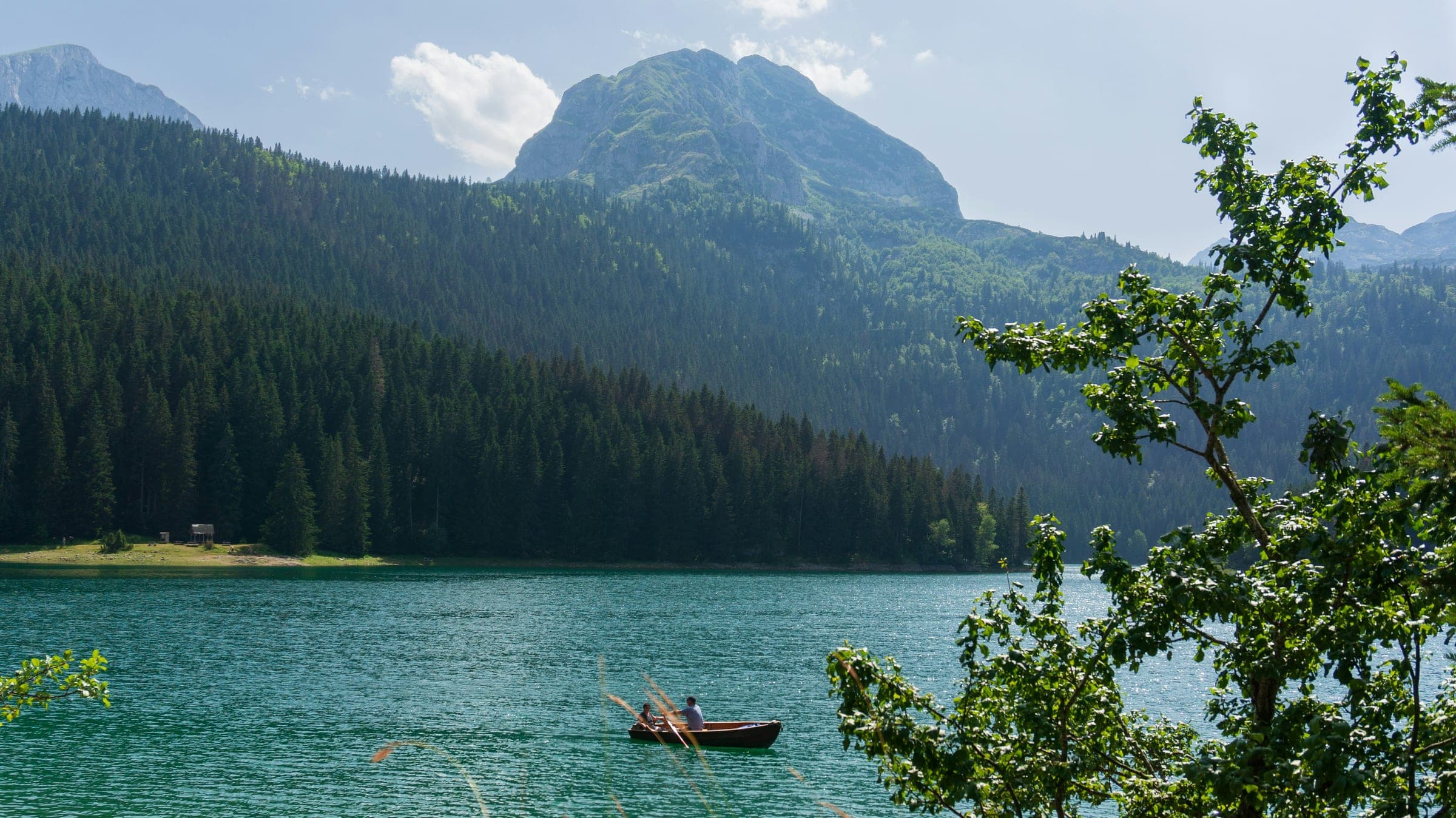 Crno jezero u Nacionalnom parku Durmitor, Crna Gora, sa čamcem i vrhom Međed
