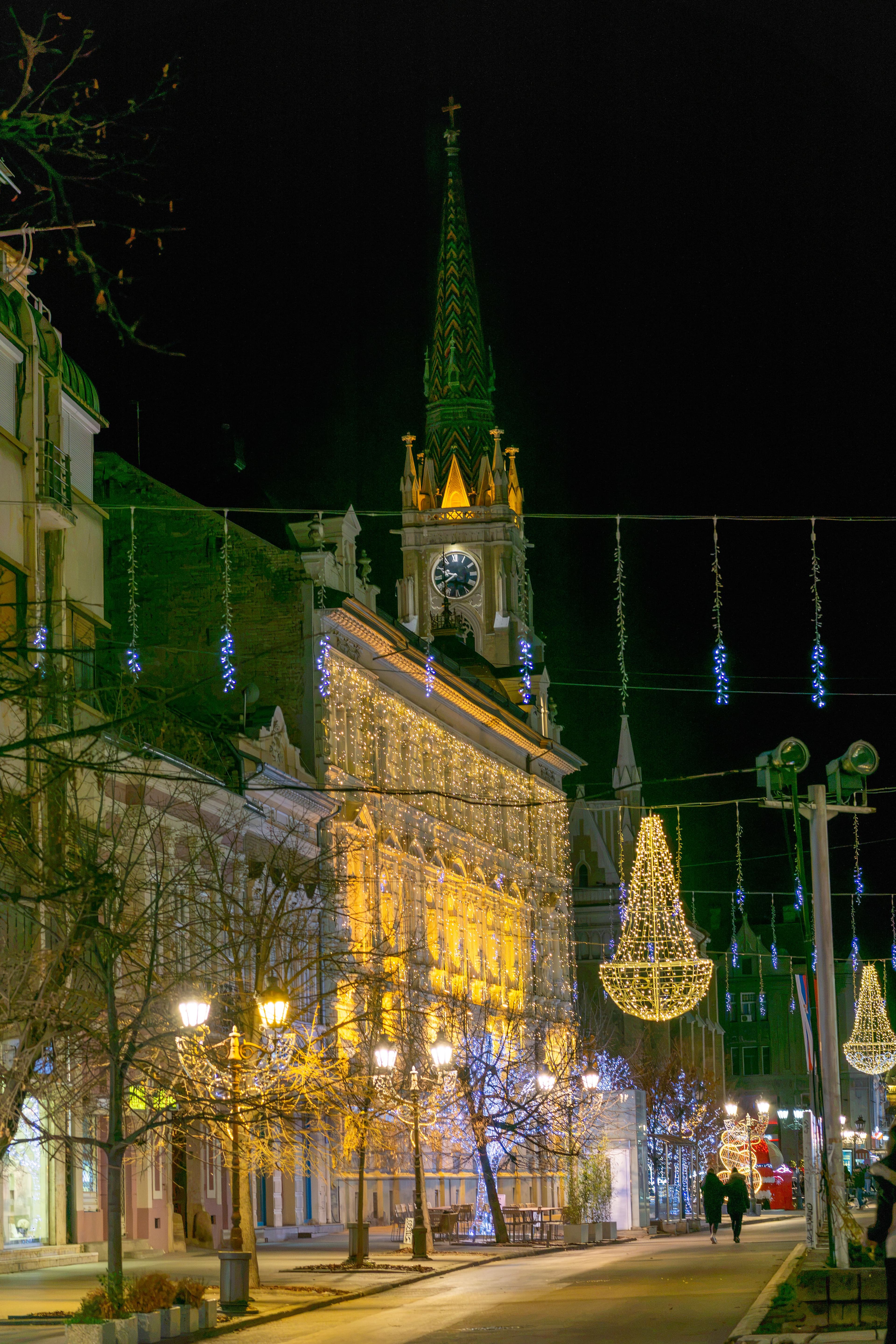 The centre of Novi Sad lit up at night, with the Name of Mary Church